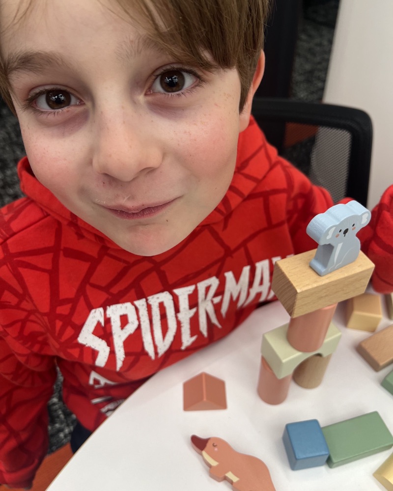 A young student building with wooden blocks